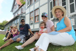 family sitting on a hill at the cape may mac sip into spring festival