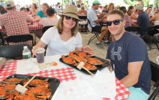boyfriend and girlfriend eating crabs and enjoying beer at the cape may mac Craft beer, Music & Crab Festival