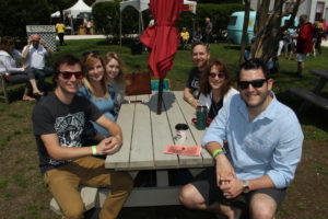 friends sitting at a picnic table at the cape may mac sip into spring festival