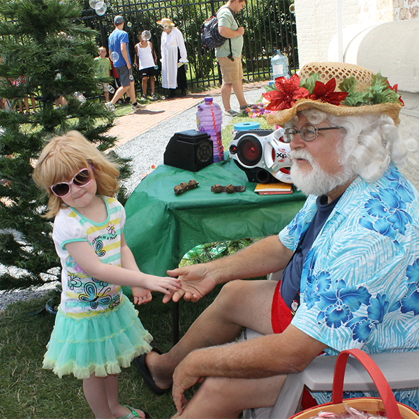 Christmas in July 600×600 Little girl meeting santa dressed in summer clothes at a CHristmas in July event at the Cape May Lighthouse