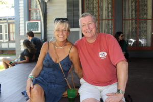 Husband and wife siting on the Emlen Physick Estate Porch enjoying the Harvest Brew Festival