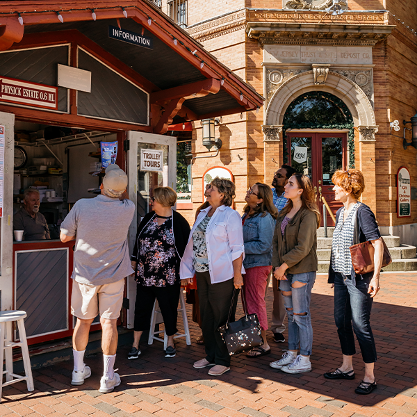 Group of people getting tickets for a tour at the Cape May MAC Information Booth on Washington Street and Ocean Street