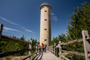 2 people looking at panels outside the World War II Lookout Tower in Cape May New Jersey