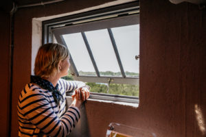 Woman inside the World War II Lookout Tower in Cape May, New Jersey, looking out a window at the beautiful view