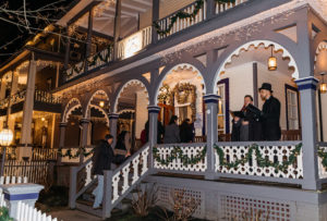 Carolers on the porch of a victorian Bed & Breakfast in cape may during the Christmas Candlelight House Tour
