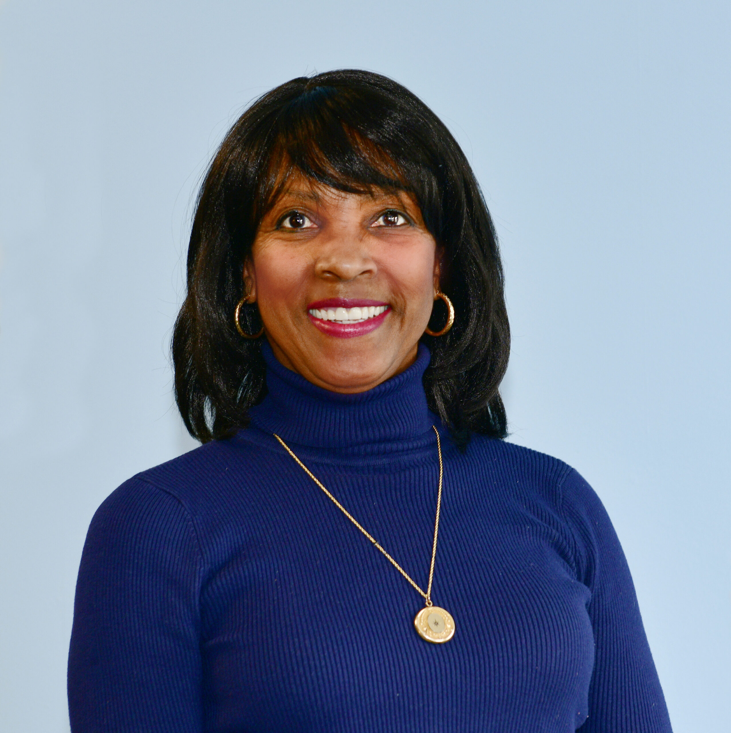 photo of a black woman in front of a light blue backdrop