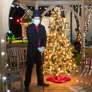 Dr Physick Christmas Mask-600×600 Dr. Physick standing outside by a lit Christmas tree.