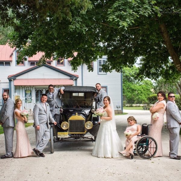 wedding group posing on a Victorian estate with a Model T car