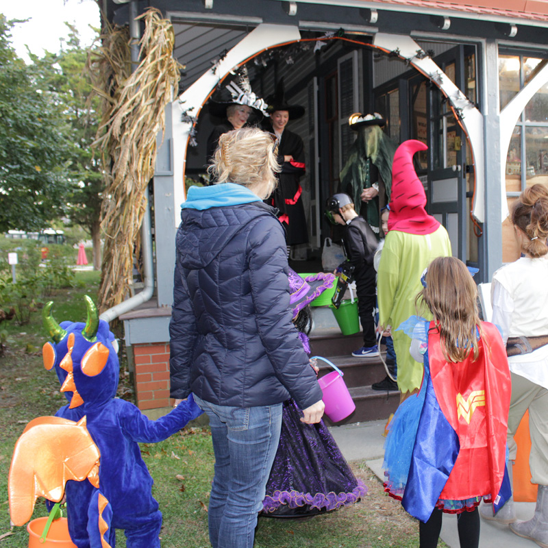 Group in Halloween costumes entering Victorian house