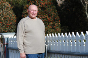Man standing next to a fence