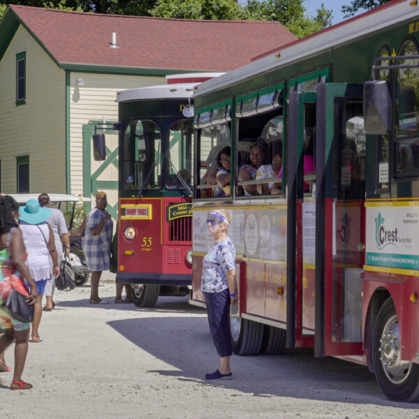 Mac_2021_photo_19 a group of people getting off a bus and onto a trolley
