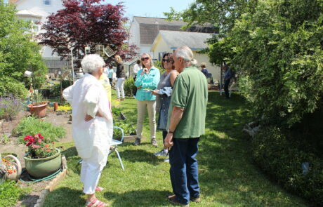 three people standing talking in a garden