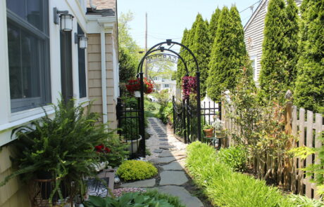 a garden arbor gate on the side of a house