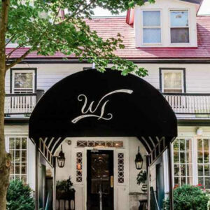 photo of the front of a restaurant with a black awning with a white W on it