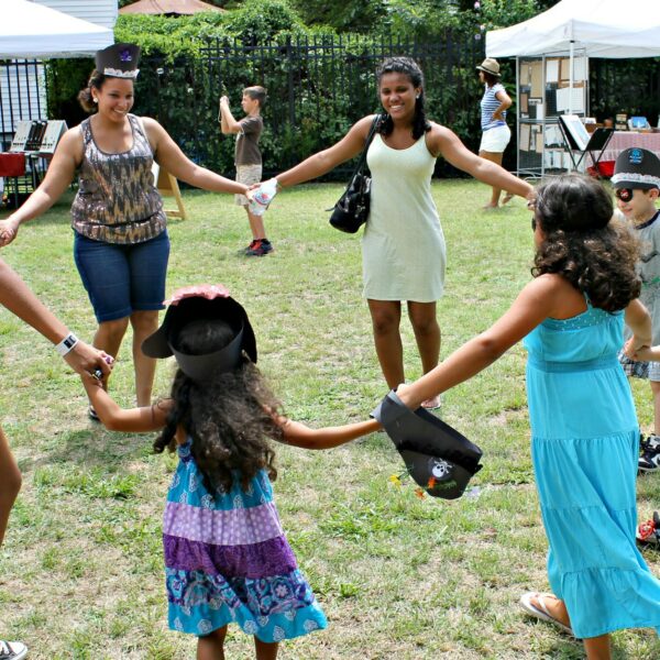 43252351152_9db1ec520a_k a family holding hands in a circle