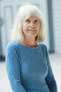 photo of a woman with grey hair and a blue shirt