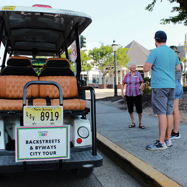 the back of a gold cart with people about to get on