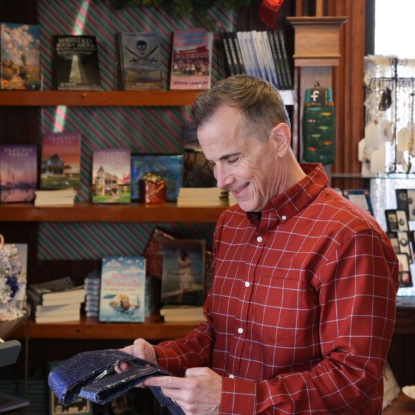 A man in a red plaid shirt shopping in a gift shop